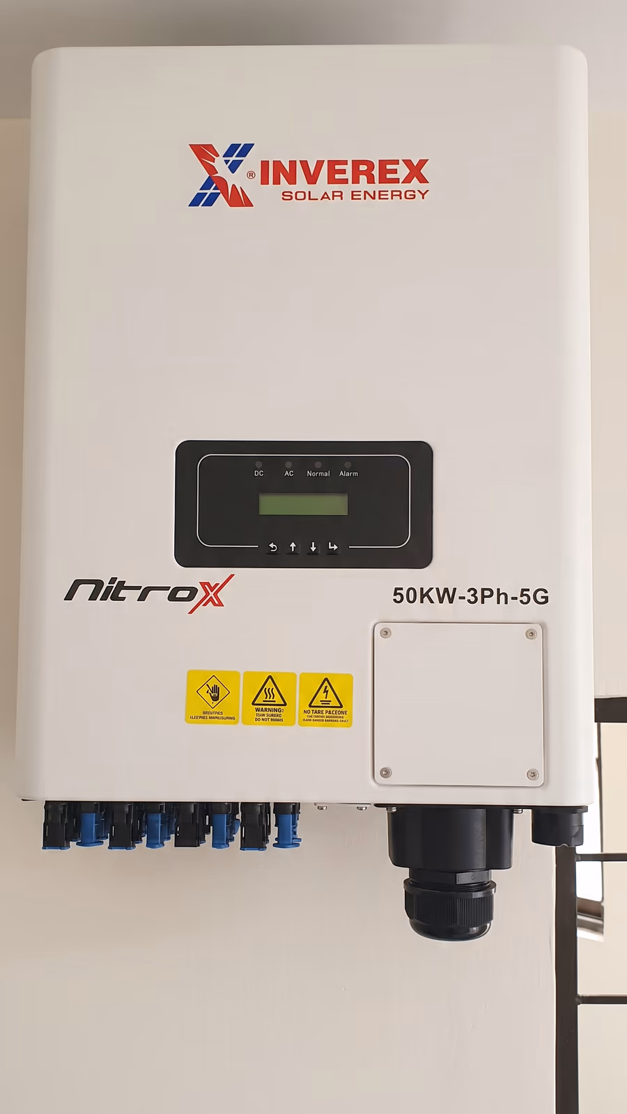 Inverex Nitrox 50 kW three-phase inverter with its display, warning labels and DC string inputs along the underside